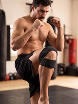 RESFIT Dual Knee Strap worn by MMA fighter in gym with visible open patella knee support